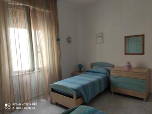 a bedroom with a bed and a dresser and a window at Sardinia ovest in Oristano