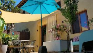 a patio with a blue umbrella in front of a house at Casa Francesca Altea piscina y aparcamiento privado in Altea