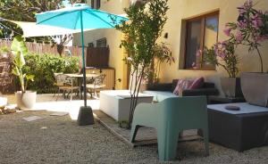 a patio with a table and a blue umbrella at Casa Francesca Altea piscina y aparcamiento privado in Altea
