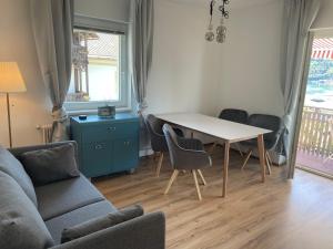 salon z kanapą, stołem i krzesłami w obiekcie Seeblick Millstatt w mieście Millstatt am See