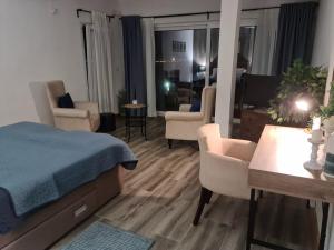 Cet appartement comprend une chambre avec un lit et des chaises ainsi qu'un salon. dans l'établissement Apartments Zec, à Čanj