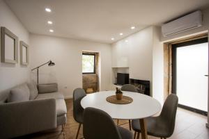 a living room with a white table and chairs at Casa dos Bernardos in Trancoso