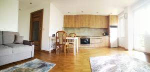 salon z kanapą i stołem oraz kuchnia w obiekcie Apartament Korczaka Centrum w mieście Suwałki