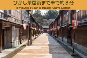 eine leere Straße in einer asiatischen Stadt mit Gebäuden in der Unterkunft Henn na Hotel Kanazawa Korimbo in Kanazawa