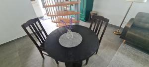 un tavolo nero con sedie e un vaso di fiori sopra di 3 ruoniai a Palanga Altre 29 foto