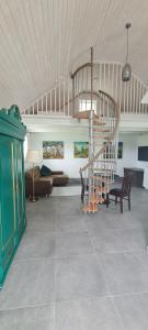 a living room with a spiral staircase in a house at 3 ruoniai in Palanga