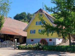 een geel en wit huis met een dak bij Winzerhof Männle in Oberkirch