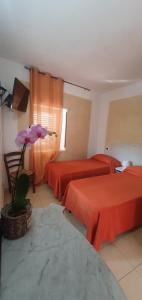 Habitación de hotel con 2 camas con sábanas rojas en Casolare Al Porto, en Tropea