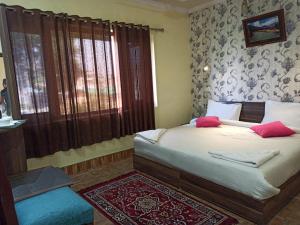 a bedroom with a bed with red pillows on it at Hotel curio's All seasons in Srinagar