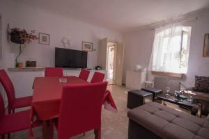 - un salon avec une table et des chaises rouges dans l'établissement Red House Veli Lošinj, à Veli Lošinj