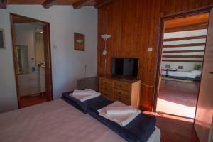 a bedroom with a bed and a flat screen tv at Red House Veli Lošinj in Veli Lošinj