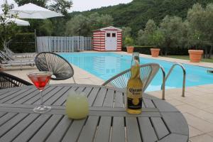 una bottiglia di champagne e un bicchiere su un tavolo a bordo piscina di Piccolo Campagna a Bagno a Ripoli