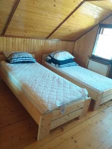 two beds in a room with wooden floors at CICHY ZAKĄTEK in Borysówka