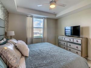 ein Schlafzimmer mit einem Bett und einem Flachbildfernseher in der Unterkunft Luxury Brand NEW 2 bedroom apt near DISNEY! in Kissimmee