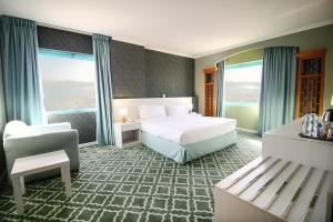 迪拜The George Hotel by Saffron, Dubai Creek的一间带床和椅子的酒店房间