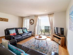 ein Wohnzimmer mit einem Sofa und einem TV in der Unterkunft Mi Casa Su Casa - Mount Brioni in Downderry