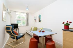 een woonkamer met een tafel en een bank bij Central Hackney Apartment in Londen