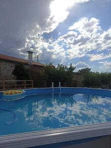 皮涅爾的住宿－Refúgio do Côa - Pure Countryside Experience，一个有阴天背景的大型游泳池
