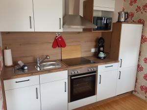 a kitchen with white cabinets and a sink at Apartment n°1 in Emmerthal