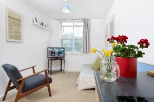een woonkamer met een tafel met bloemen in een vaas bij Central Hackney Apartment in Londen
