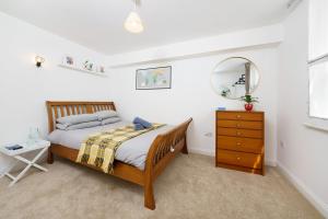 a bedroom with a bed and a mirror and a dresser at Central Hackney Apartment in London