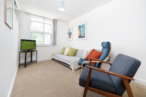 a living room with a couch and a tv at Central Hackney Apartment in London