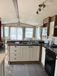 a kitchen with a sink and a stove top oven at Seascape Coastal Venture at Camber Sands in Camber