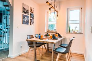 カロリーネンジールにあるFerienhaus Steuerbord mit Kamin und Terrasse - 4 Sterne DTV-Klassifizierungのテーブルと椅子のあるダイニングルーム