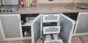 een aanrecht met witte lades en een wastafel bij appartement boukidan in Al Hoceïma