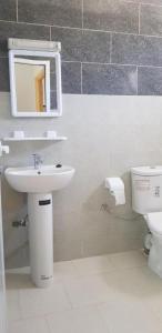 bagno con lavandino, servizi igienici e specchio di appartement boukidan ad Al-Ḥoseyma