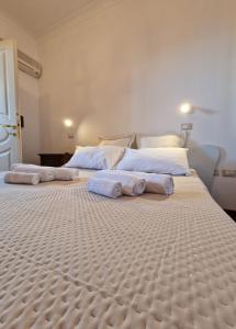 uma grande cama branca com toalhas em cima em Residenza Estea em Tropea