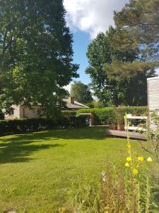 a backyard with a lawn with a picnic table and trees at Strande, fast am Strand in Strande