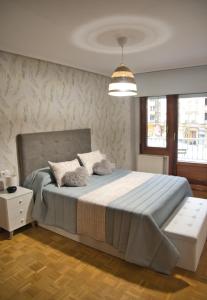 阿維萊斯的住宿－La Villa De Lore, Piso Completo Apto 6 Personas，一间卧室配有一张大床和一个吊灯。