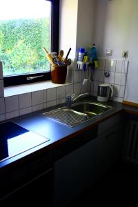 encimera de cocina con fregadero y ventana en Strande, fast am Strand, en Strande
