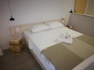 a bedroom with a white bed with towels on it at APARTMENTS BY THE SEA in Gázion