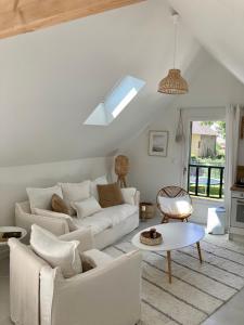 ein Wohnzimmer mit einem weißen Sofa und einem Tisch in der Unterkunft Studio cosy avec coin jardin in Lancieux