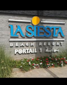 ein Schild für ein Strandresort mit Blumen davor in der Unterkunft luxu appart siesta beach resort in Mohammedia