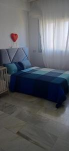 ein Schlafzimmer mit einem blauen Bett und einem roten Kissen in der Unterkunft luxu appart siesta beach resort in Mohammedia