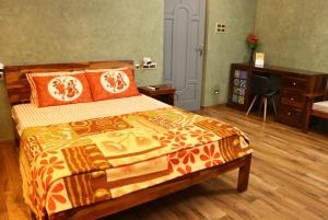 a bedroom with a bed and a desk and a chair at Penthouse 2BHK with Bathtub and Terrace in Puducherry