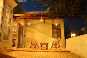 two chairs and a table on a patio at night at Penthouse 2BHK with Bathtub and Terrace in Pondicherry