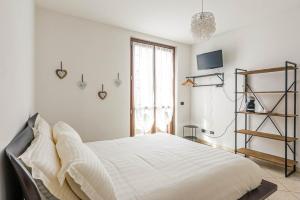 Un dormitorio blanco con una cama grande y una ventana en Le Quattro Stelle Villa, en Cardano al Campo