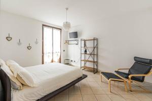 a bedroom with a bed and a chair at Le Quattro Stelle Villa in Cardano al Campo