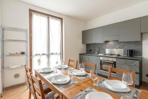 comedor con mesa y sillas y cocina en Le Quattro Stelle Villa, en Cardano al Campo