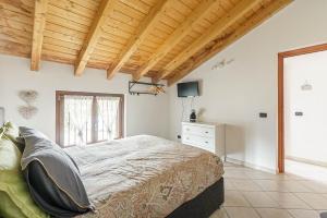 1 dormitorio con 1 cama grande y techo de madera en Le Quattro Stelle Villa, en Cardano al Campo
