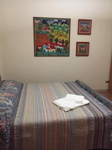 Bett in einem Zimmer mit einem Bild an der Wand in der Unterkunft LA CASA TRA GLI OLIVI in Sona
