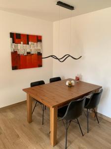 een eettafel met stoelen en een schilderij bij Apartment Number 8 in Crans-Montana