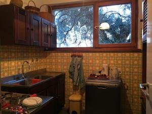 a small kitchen with a sink and a window at LA CASA TRA GLI OLIVI in Sona