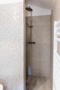 um chuveiro na casa de banho com uma parede de azulejos em S271 - Sirolo, deliziosa mansarda condizionata arredata con gusto em Sirolo