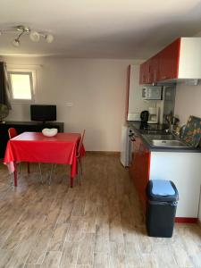 a kitchen and a table with a red table cloth at A Stalla in Piana