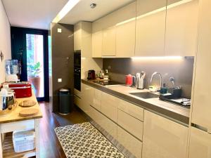 a kitchen with white cabinets and a sink at Vill'Amar Tróia in Troia